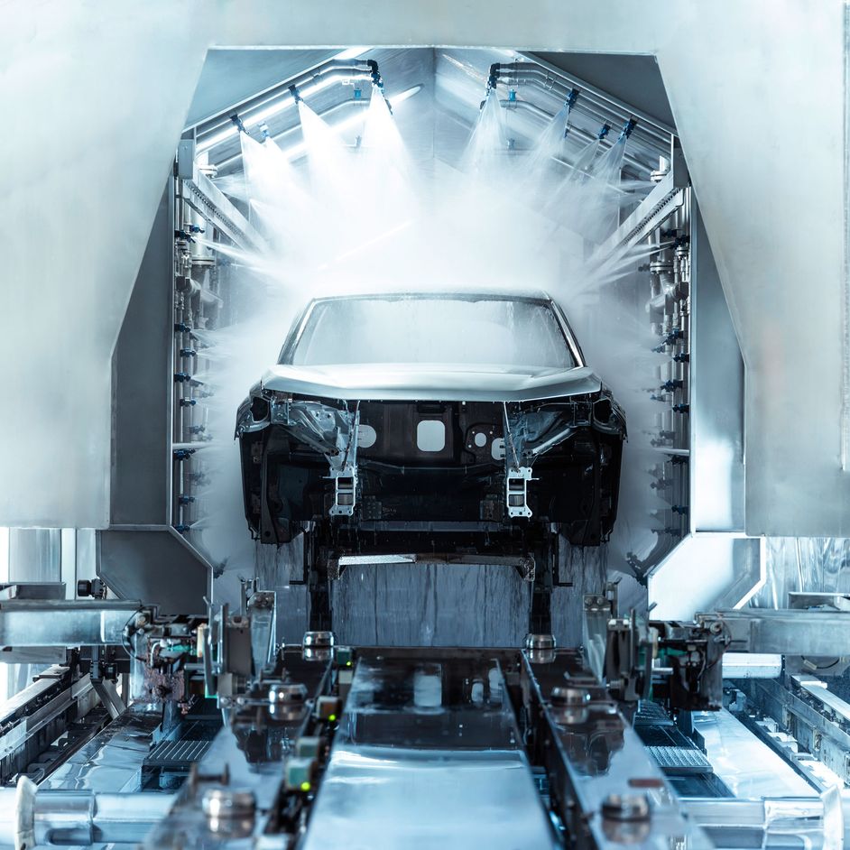 A car is sprayed by application robots in the paint shop