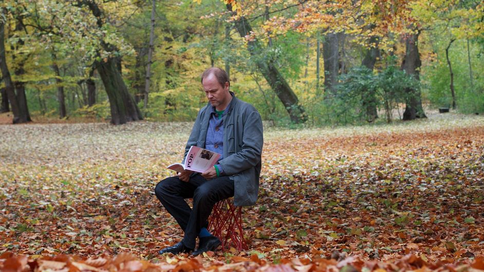 Wolfgang Ullrich liest eine Zeitschrift im Wald