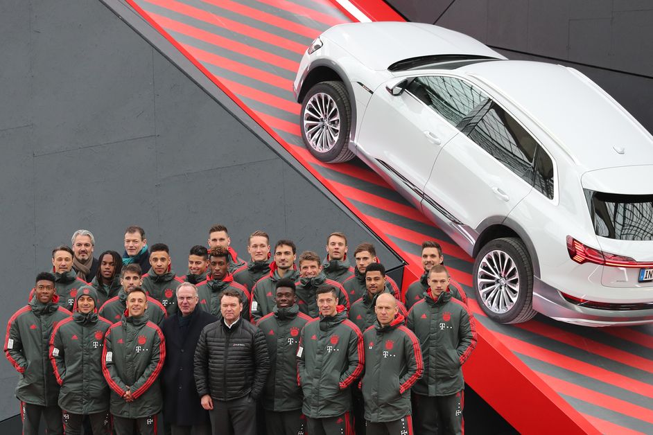 Teambild des FC Bayern neben einem Audi e-tron