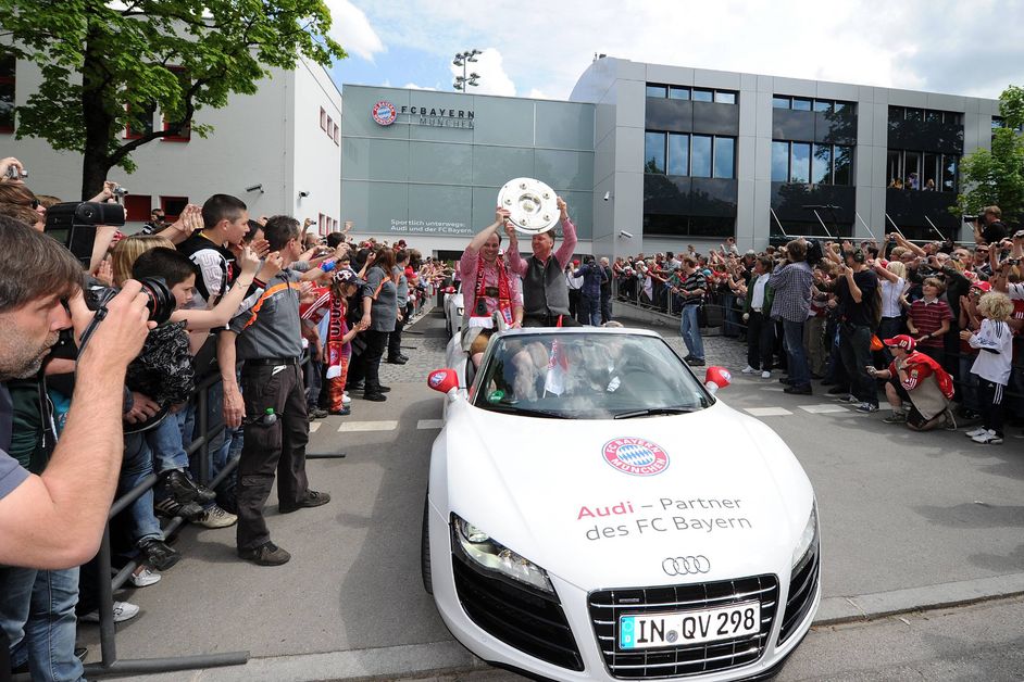 Bayern professionals raise the championship trophy in the air from a white Audi cabriolet