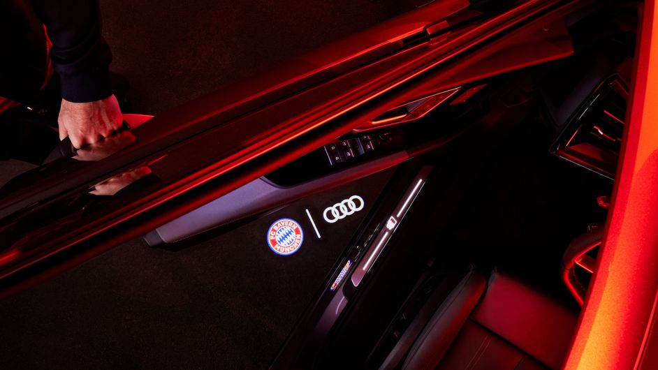 FC Bayern and Audi logo are projected onto the floor under the vehicle door. 
