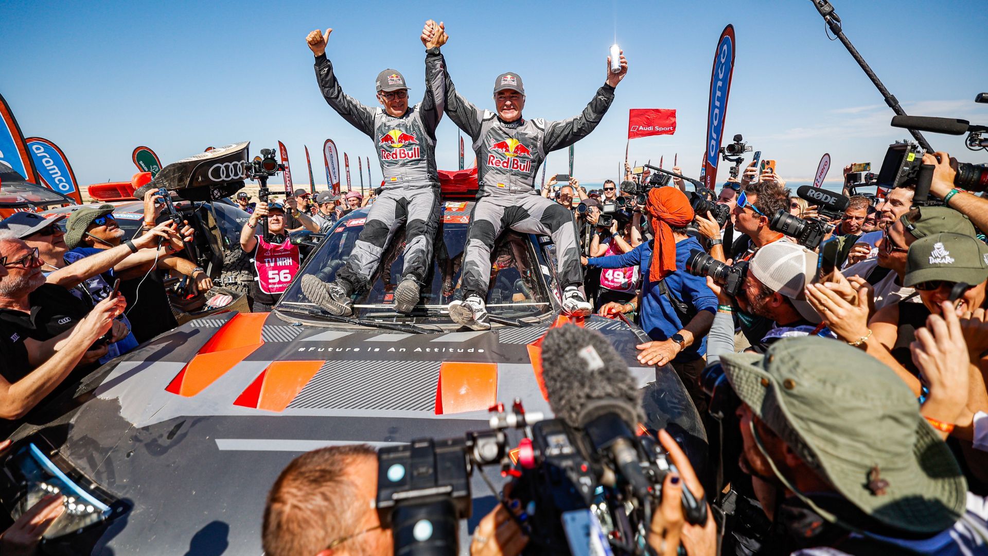 Die Spanier Carlos Sainz (r.) und Lucas Cruz jubeln im Ziel über den ersten Audi Sieg bei der Rallye Dakar