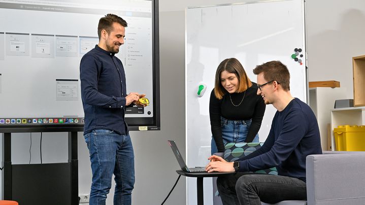 Lisa, Product Designerin SDC, schaut mit einem Kollegen auf einen Laptop