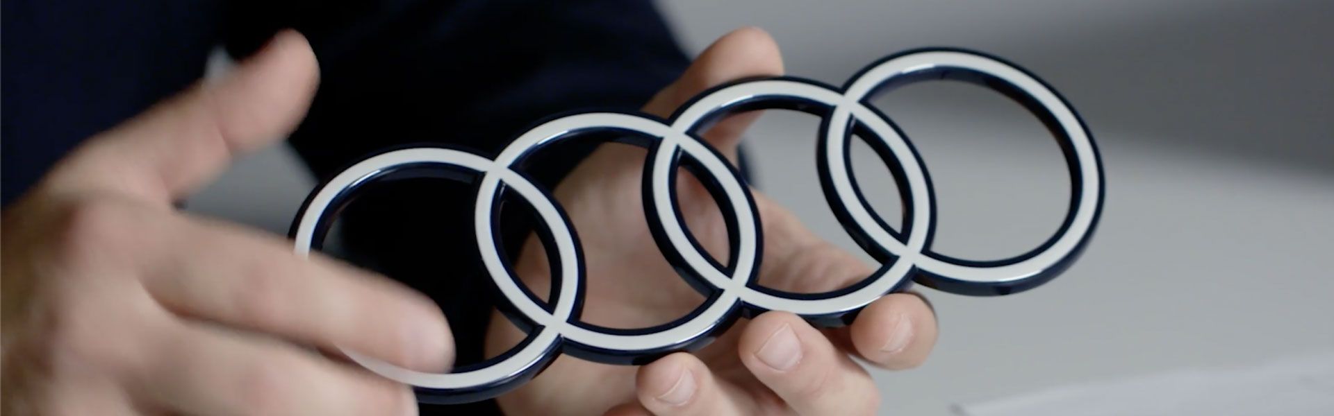 Hände halten ein Audi Logo als Profil