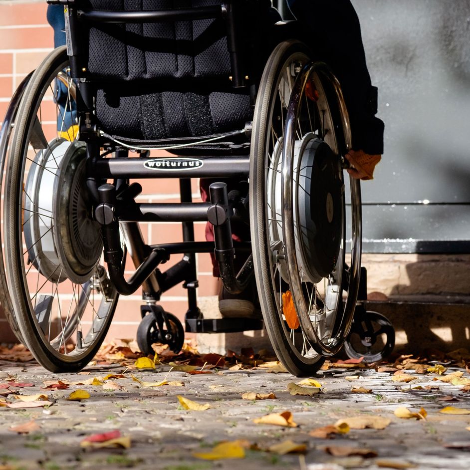 Wheelchair user in front of a high step at the entrance of the house