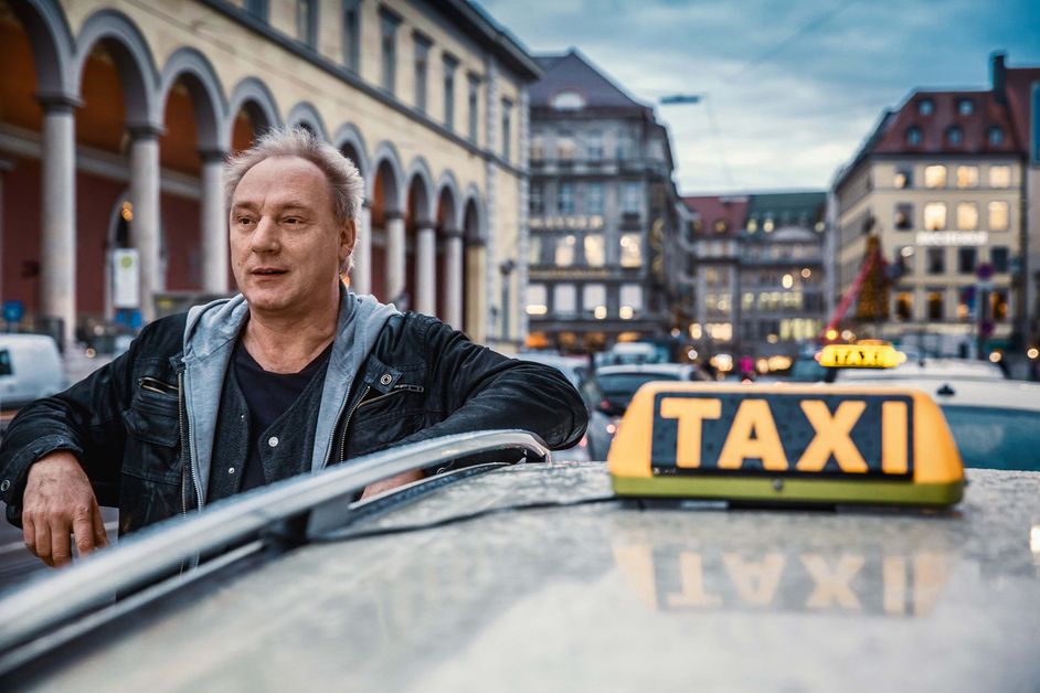 Taxifahrer Franz Daumer lehnt an seinem Wagen.