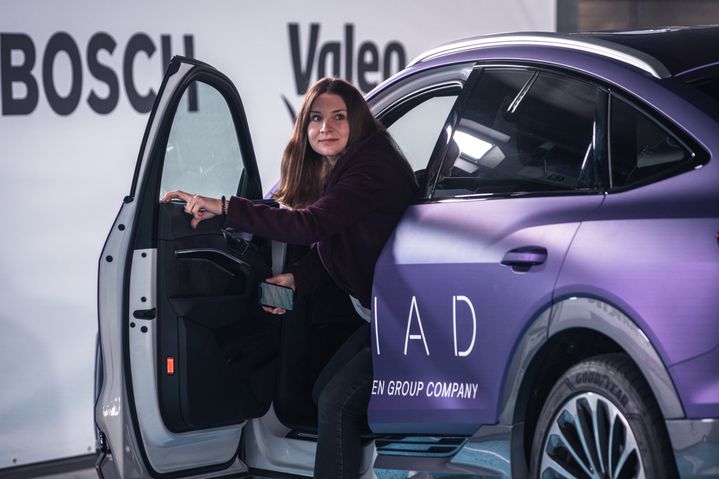 Woman getting out of a purple Audi