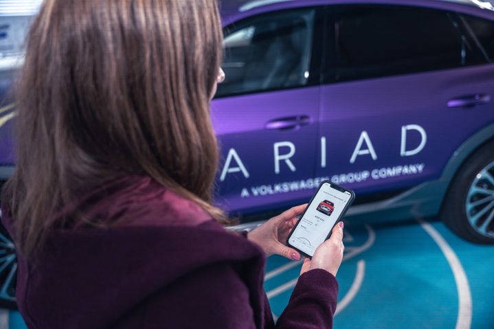 Frau schaut auf ein Handydisplay mit der Automated Valet Parking App