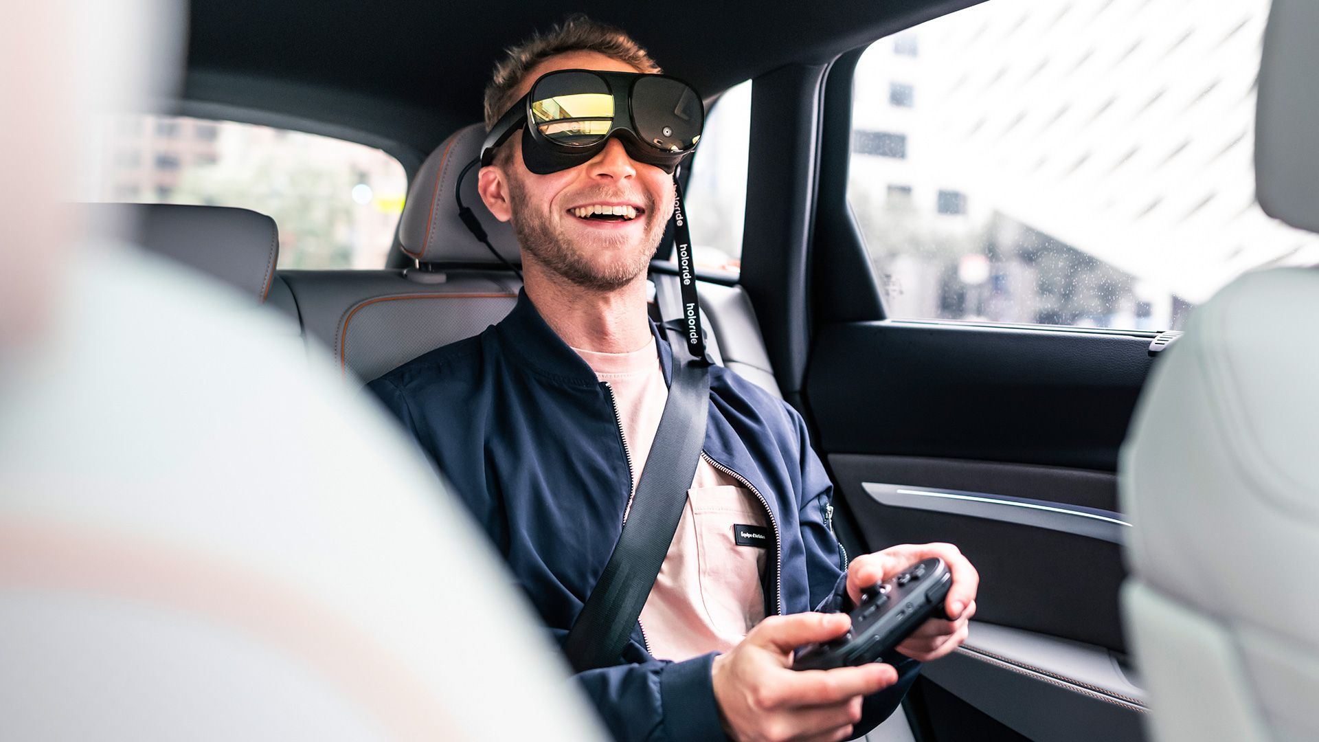 Junger Mann mit Virtual Reality Brille auf der Rückbank eines Audi e-tron