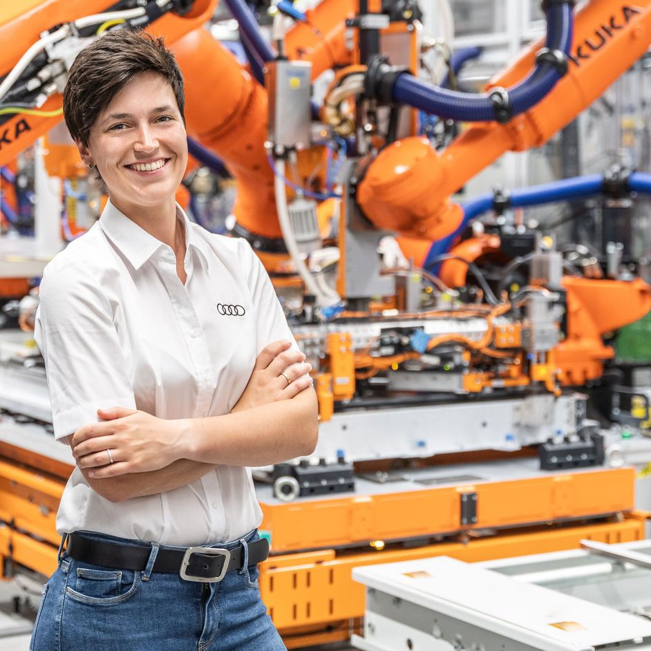 Maria Salbeck in front of robots in battery assembly