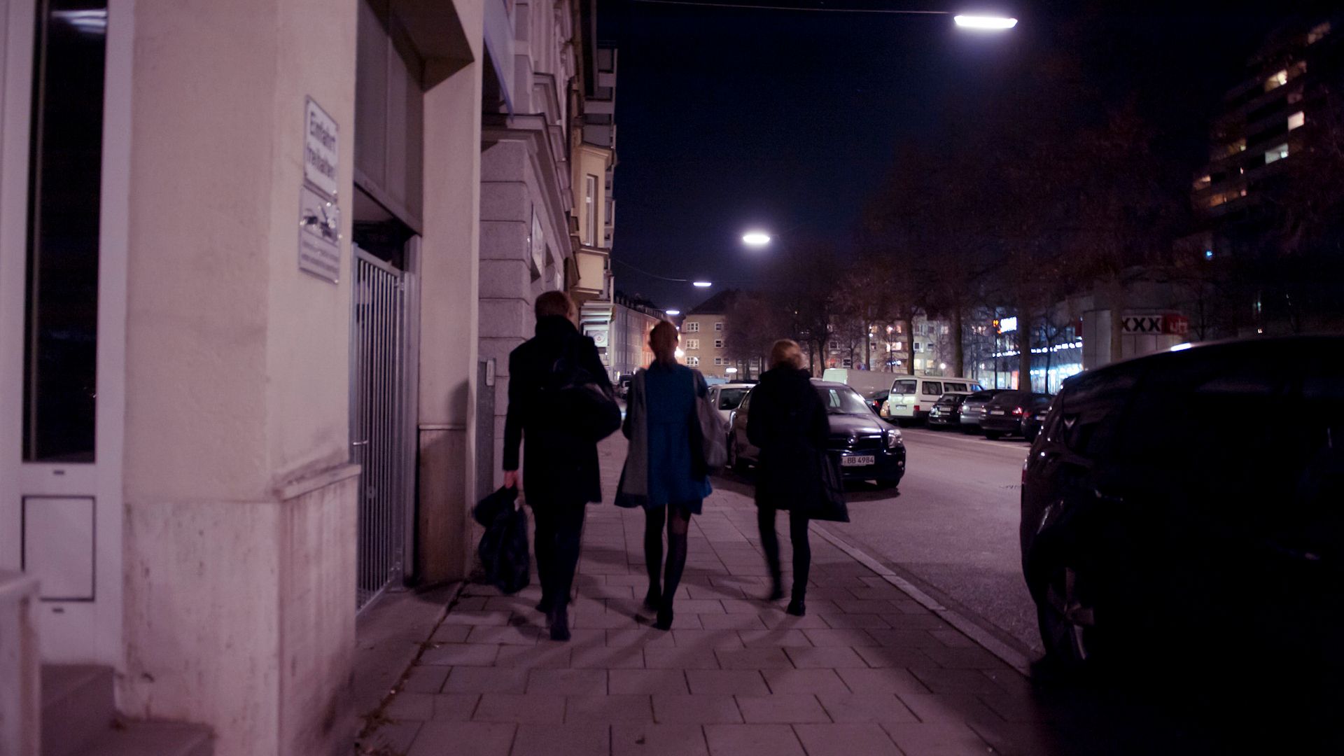 People walking in the dark on a sidewalk