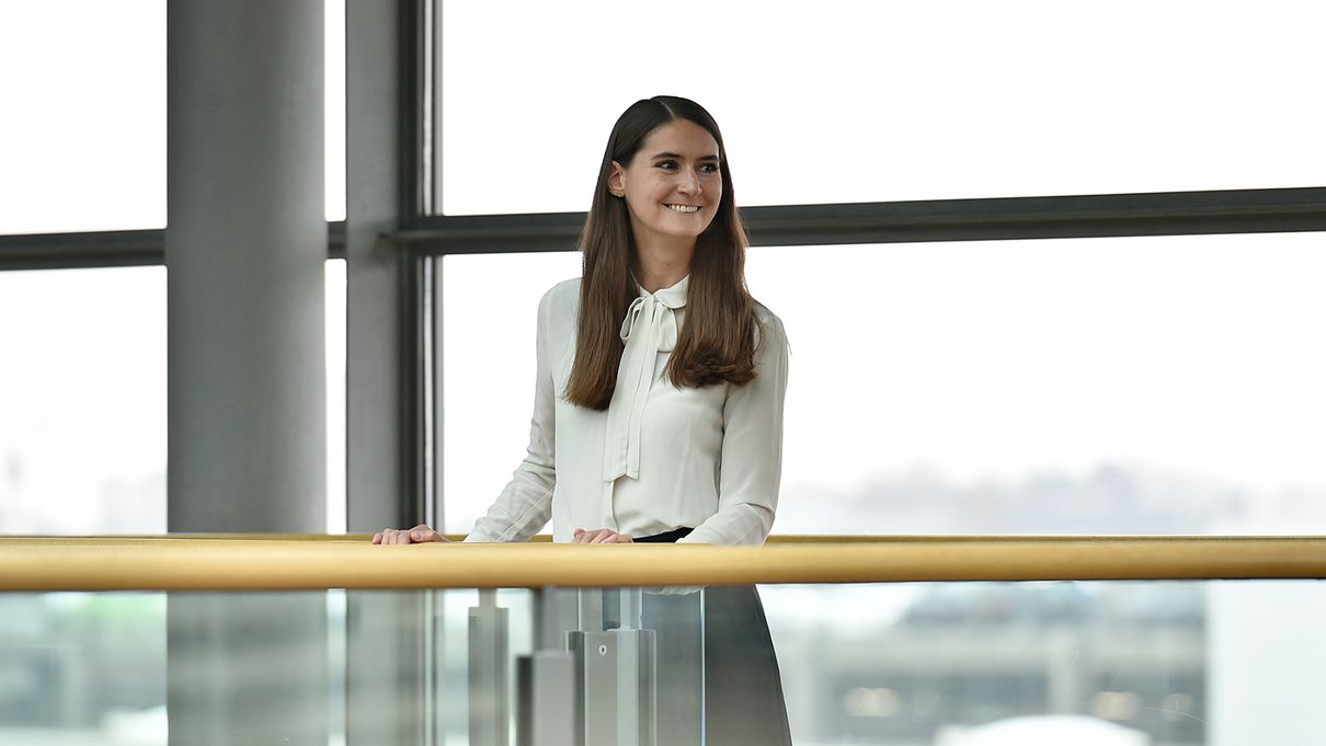 Saskia Lexen stands smiling at a glass railing