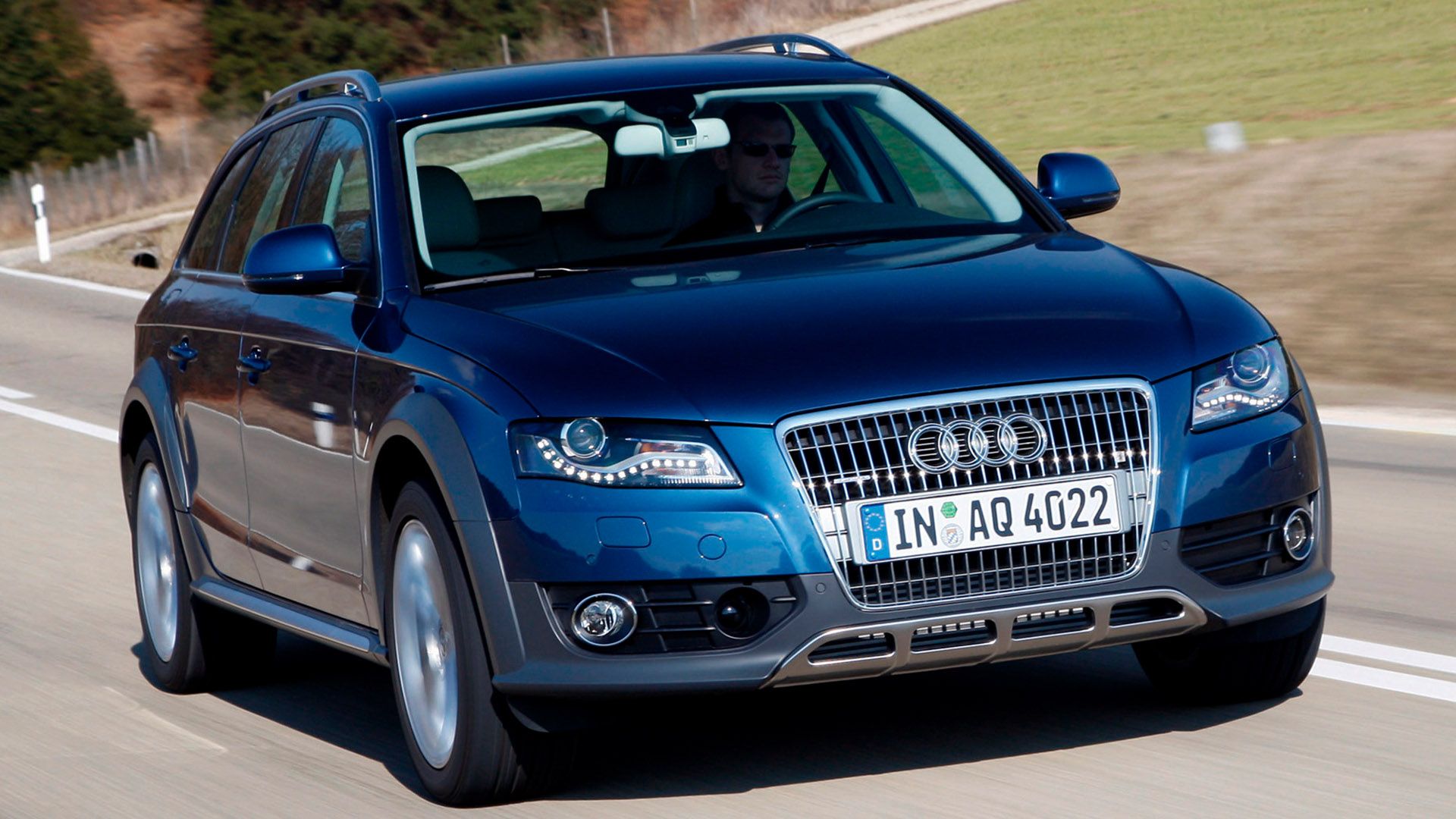 Dark blue Audi A4 allroad quattro driving on a country road