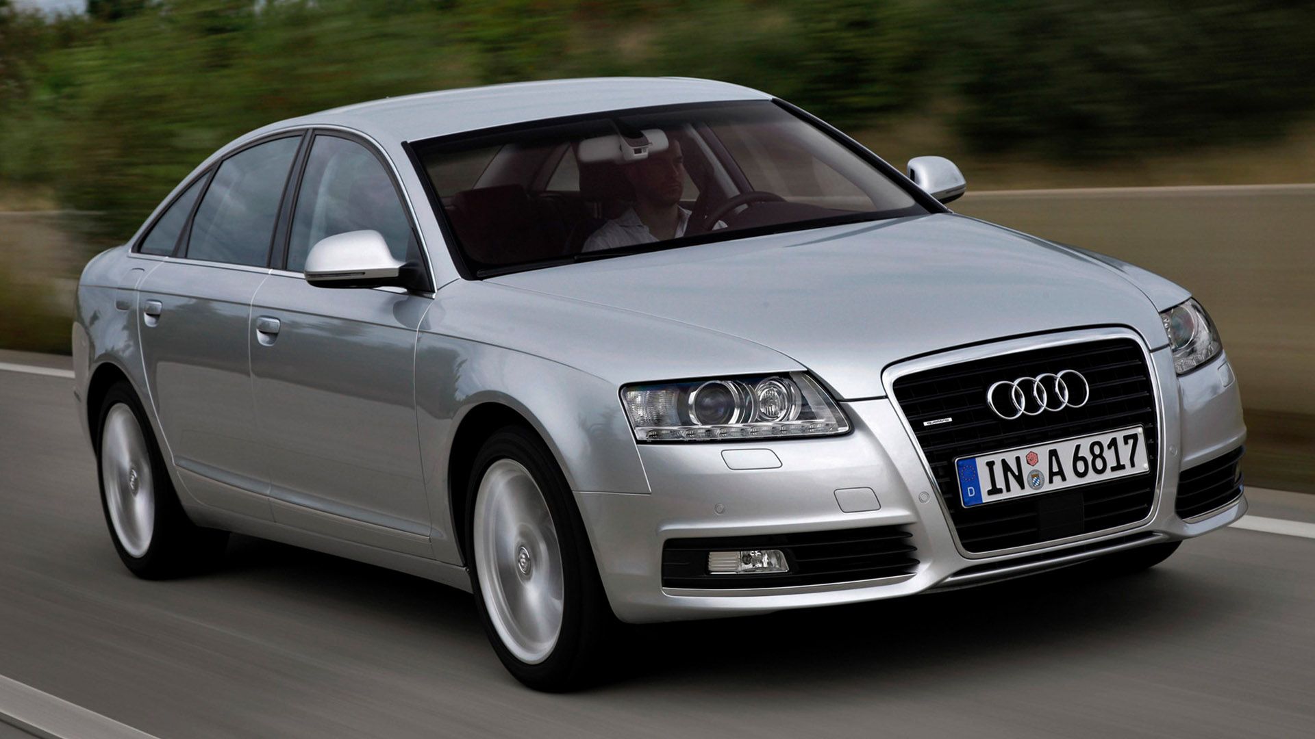 Grey Audi A6 sedan driving on a country road