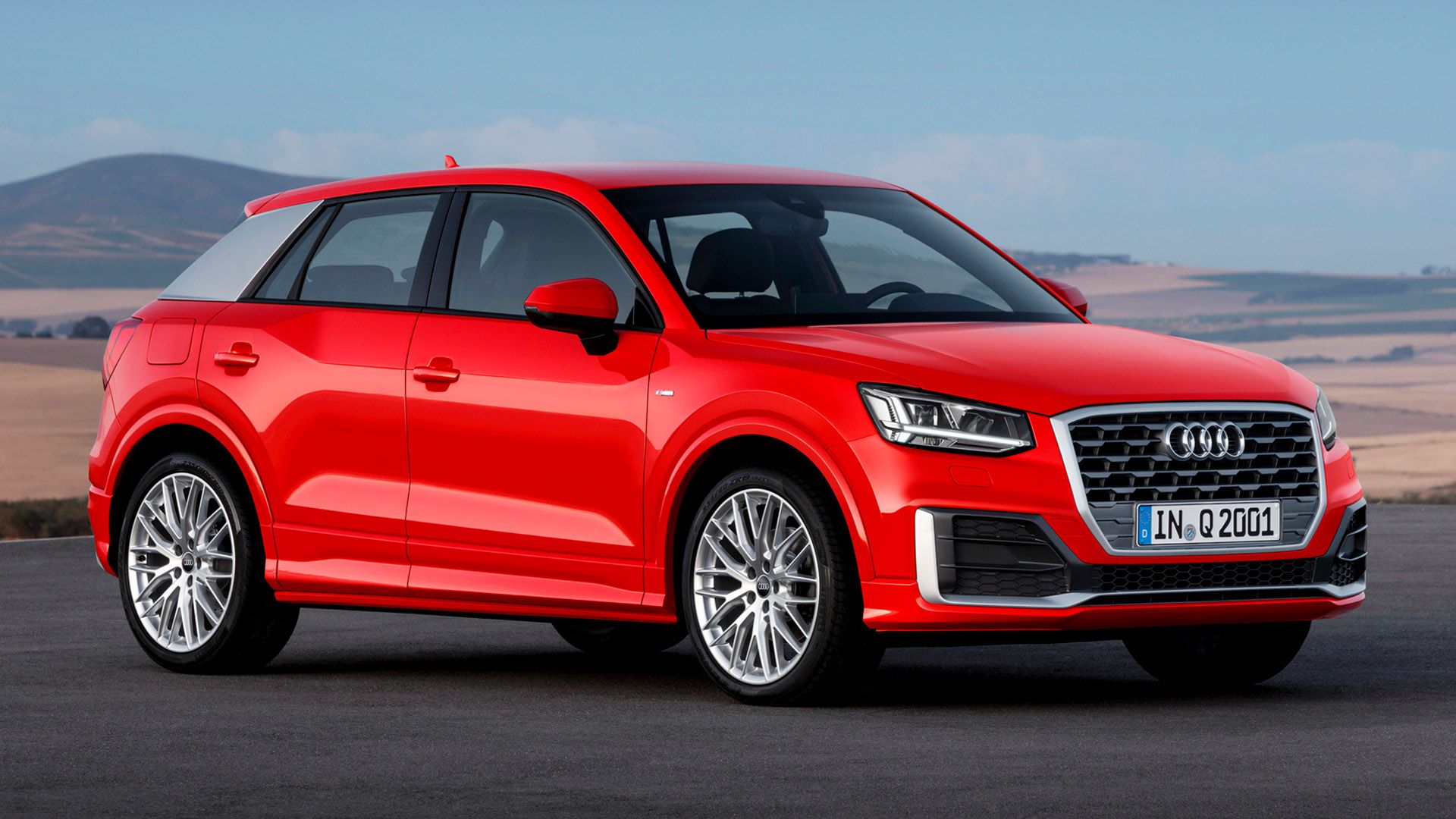 Red Audi Q2 in front of a mountain range