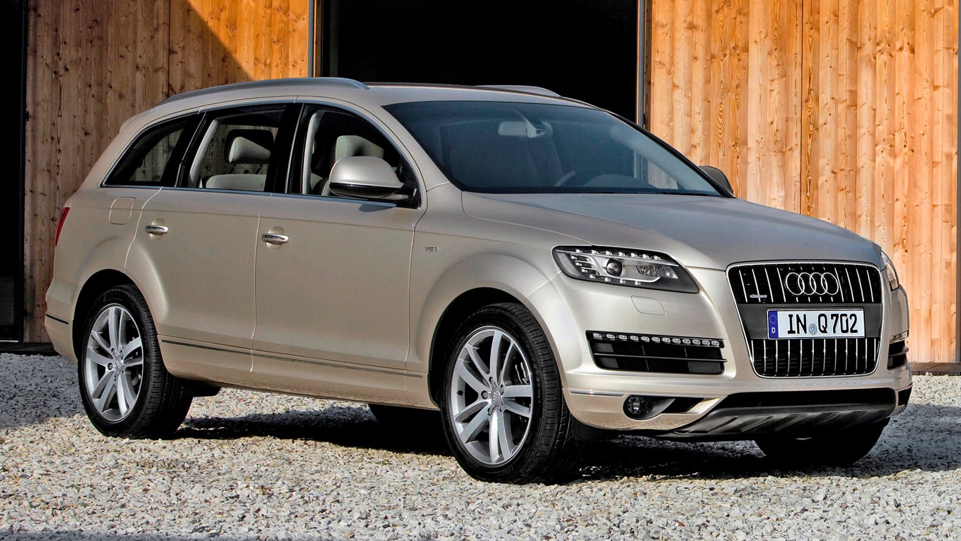 Silver Audi Q7 in front of a wooden building