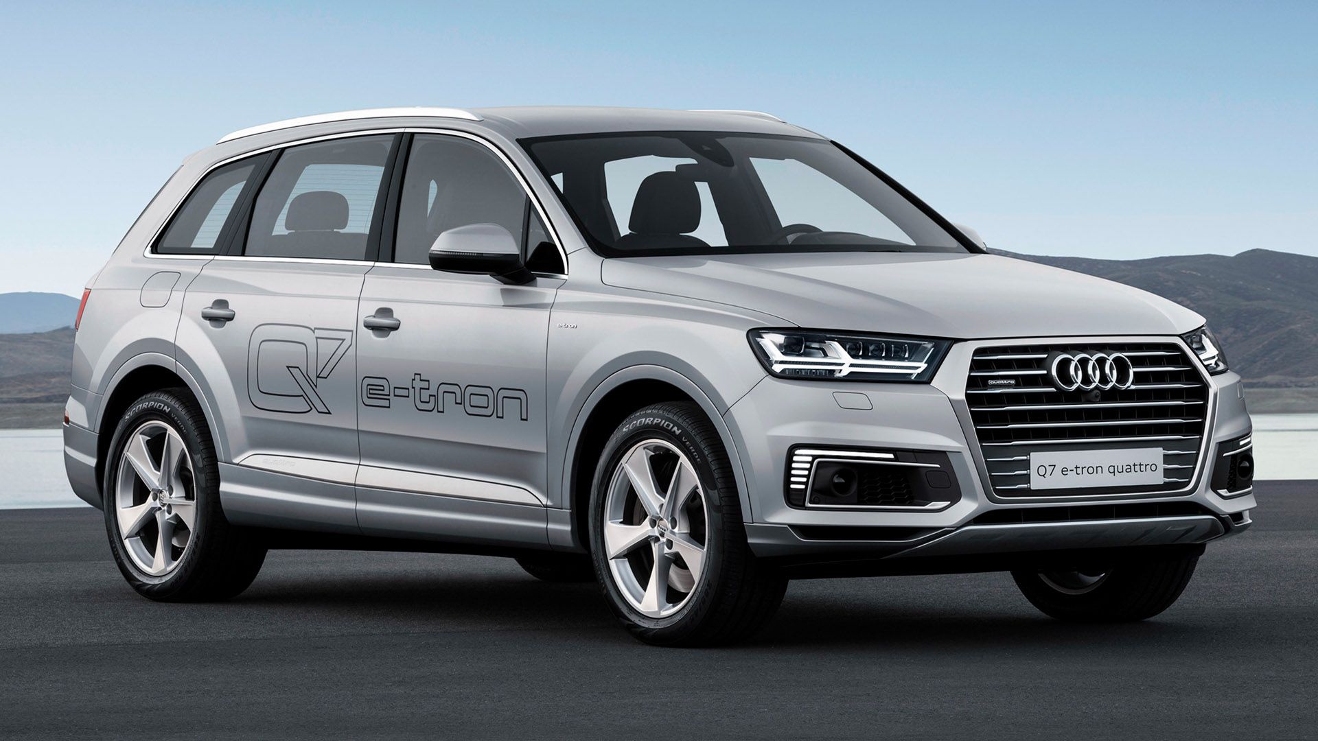 Silver Audi Q7 e-tron in front of a lake