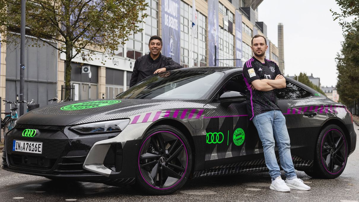 Two men stand in front of the Audi RS e-tron GT FC Bayern concept*. 
