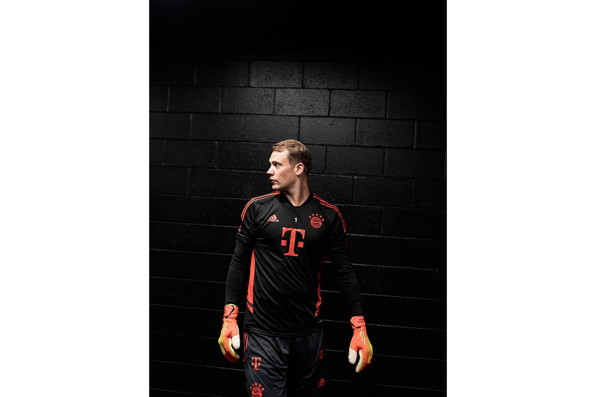 Manuel Neuer in schwarzem Trikot vor einer schwarzen Wand