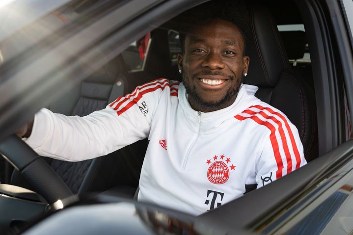 Alphonso Davies vom FC Bayern lächelt bei der FC Bayern Fahrzeugübergabe