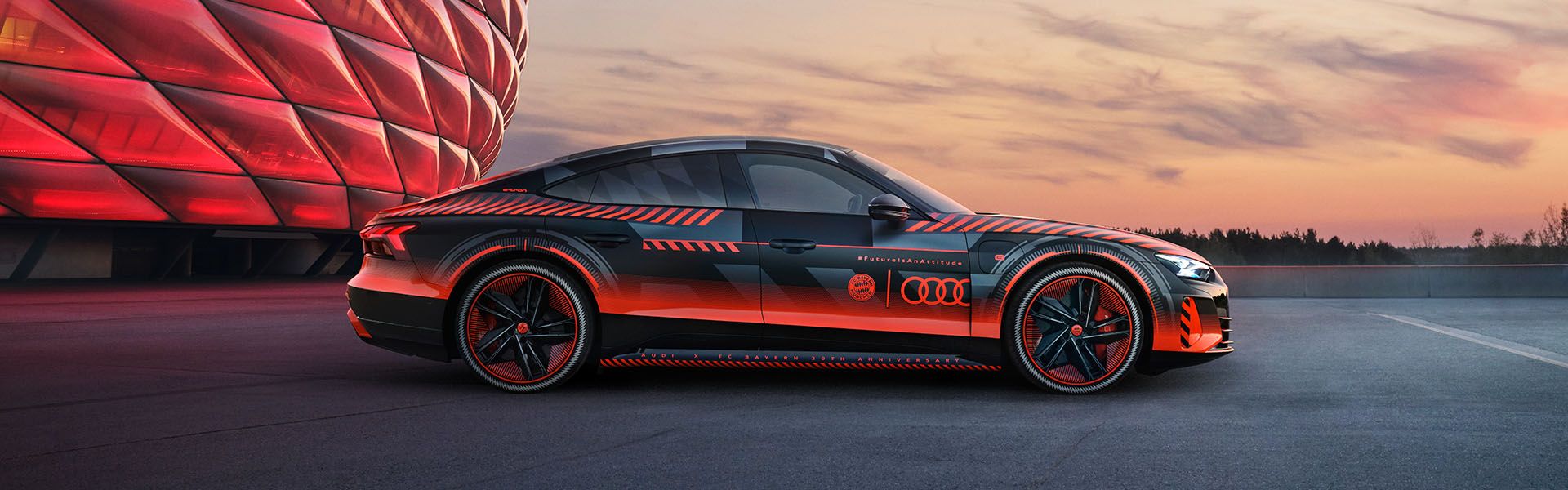 The Audi RS e-tron GT FC Bayern concept with special red livery in front of the Allianz Arena