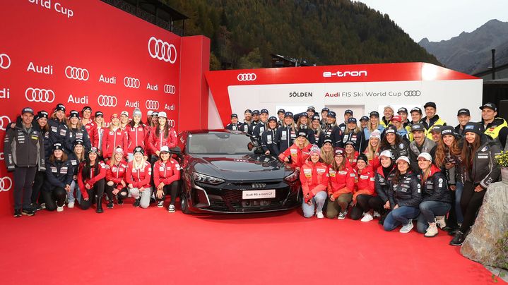 A group photo at the FIS Ski World Cup in Sölden. In the centre is a black Audi.