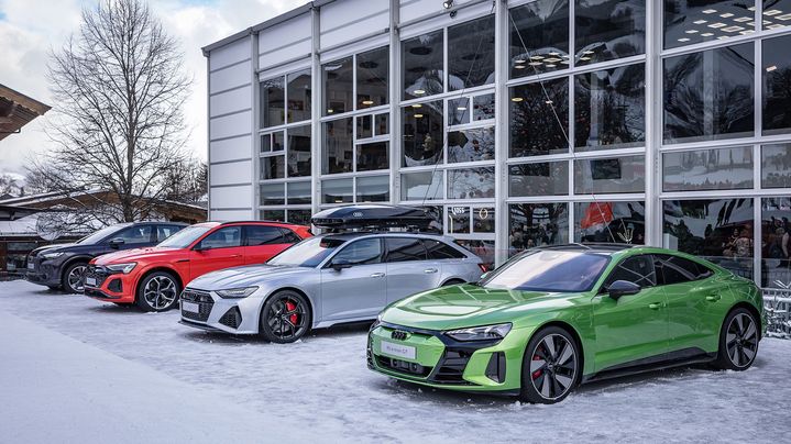 Several Audis in different colours (black, red, silver, green) stand side by side.
