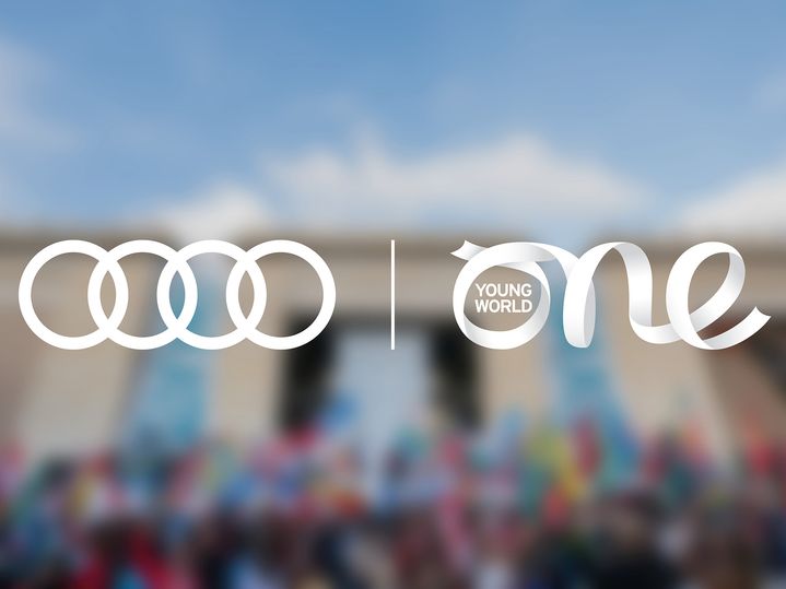 Audi und One Young World Summit Logos über veschwommenem Gruppenbild