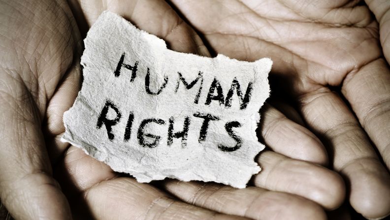Hände halten einen Zettel mit der Aufschrift Human rights