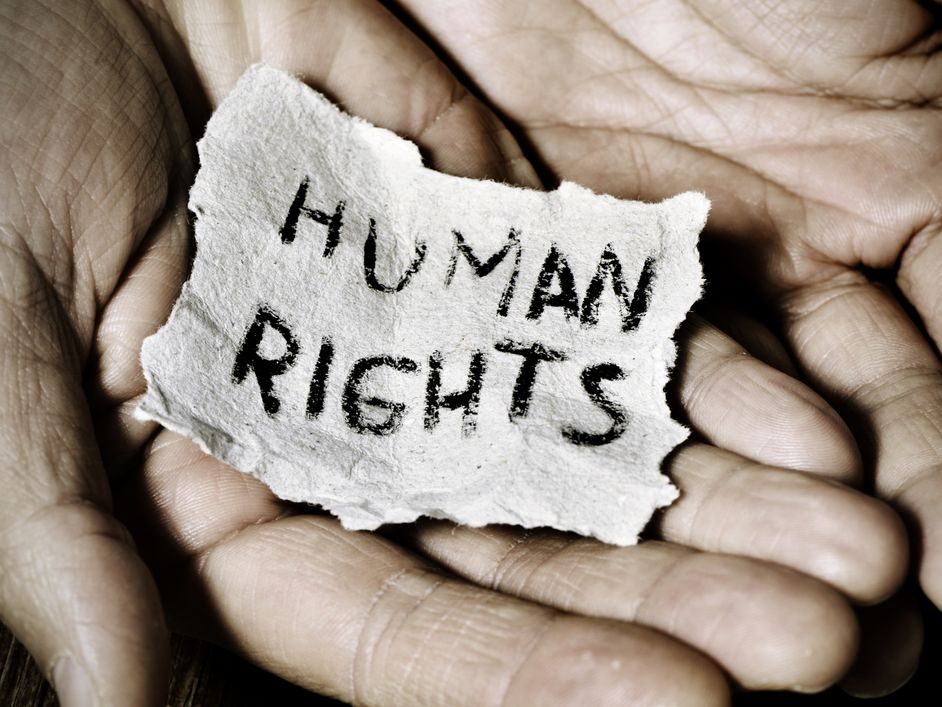 Hands holding a piece of paper that reads Human Rights